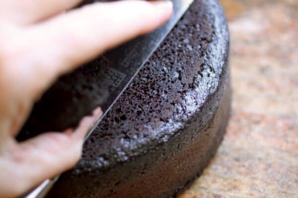 slicing the top off of the cake