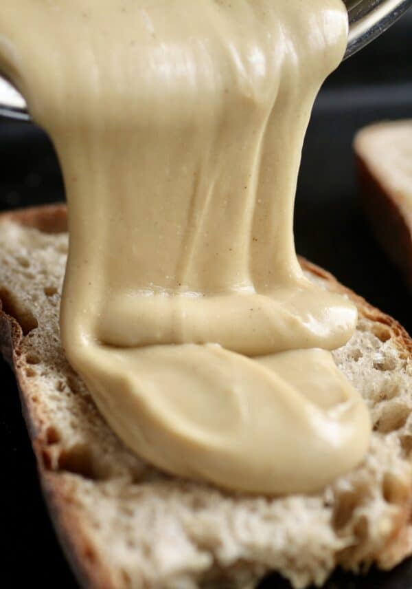 pouring cheese sauce on toasted bread