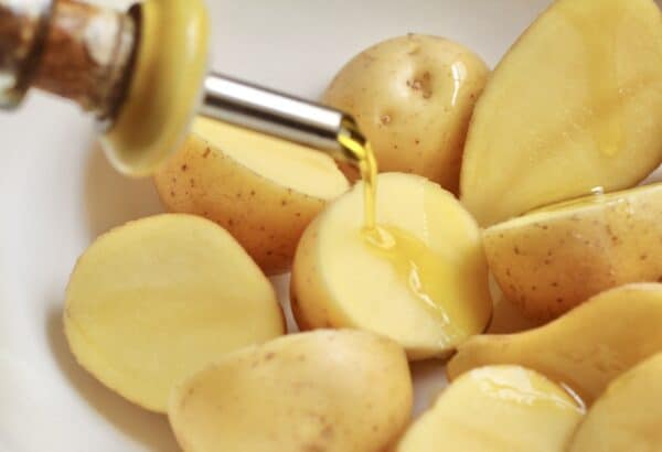 putting oil on potatoes