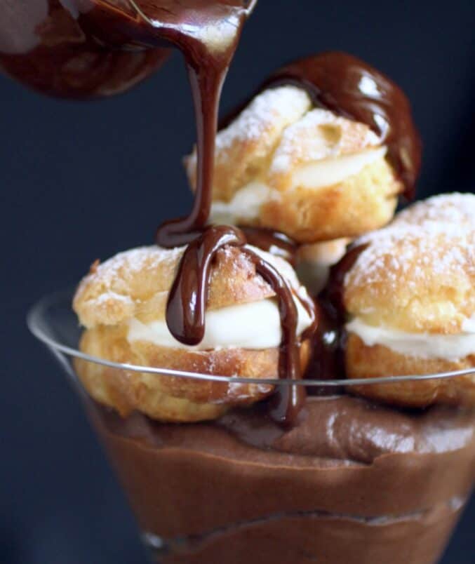 pouring sauce on profiteroles