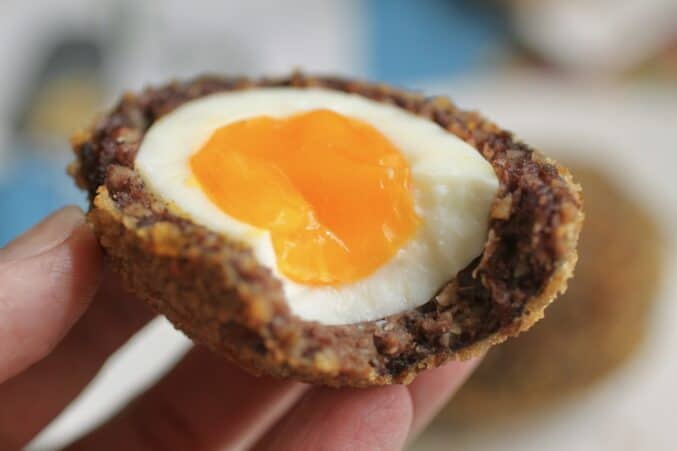 eating a Scotch egg made with black pudding and sausage