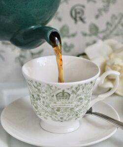 pouring loose leaf British tea into a Coronation cup