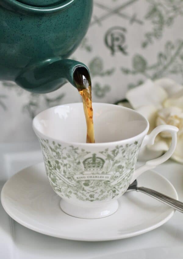 pouring loose leaf British tea into a Coronation cup