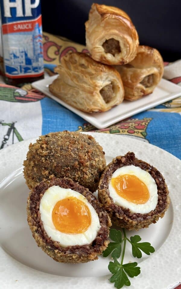 black pudding Scotch egg cut in half, sausage rolls and HP Sauce