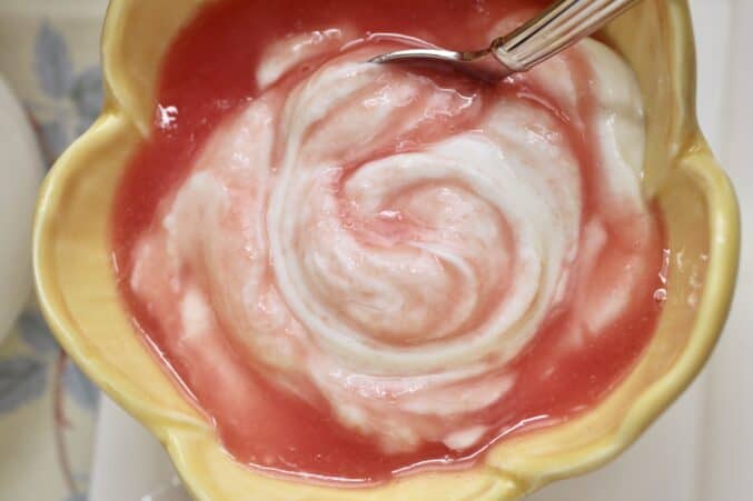 Stirring the pink sauce into yogurt.