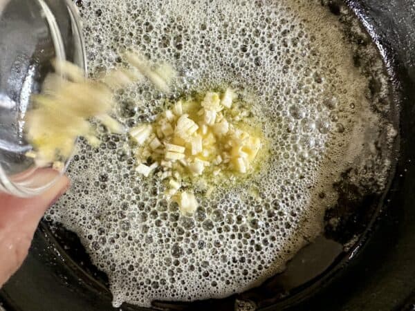 adding garlic to pan