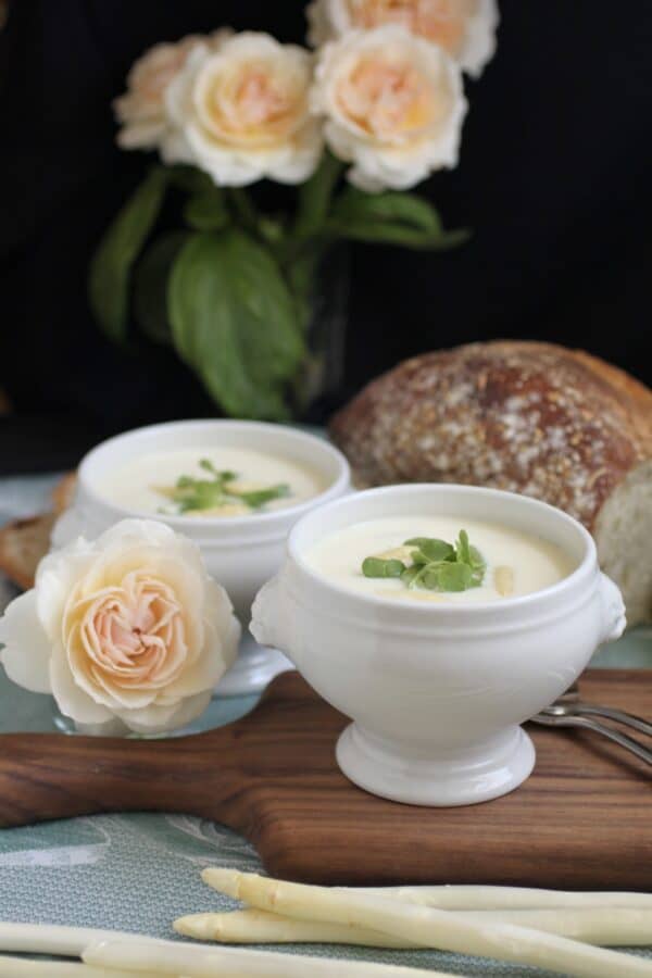 asparagus soup in lion's head bowls with a rose and bread