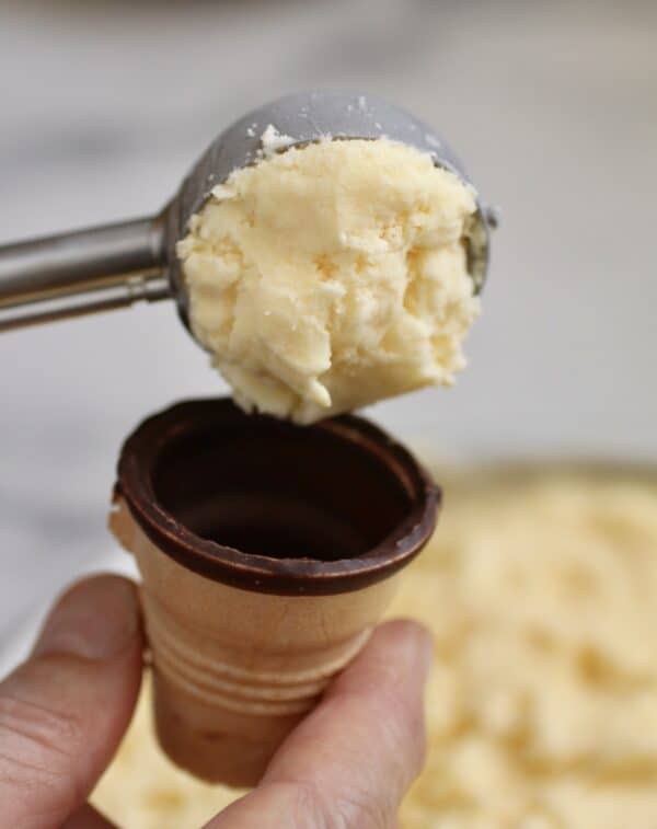 scooping mango ice cream into mini cone