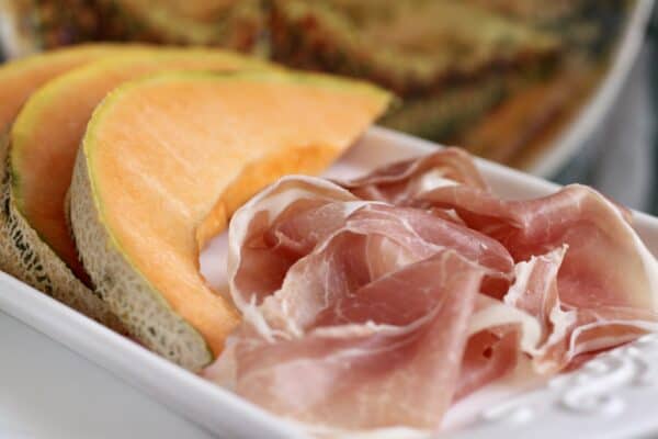 prosciutto with tuscan melon slices on plate