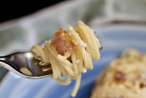 pasta with bacon and eggs on fork