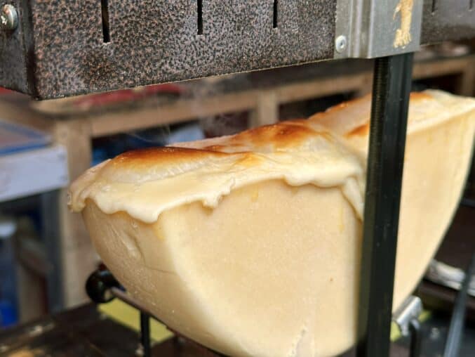 half wheel of raclette melting