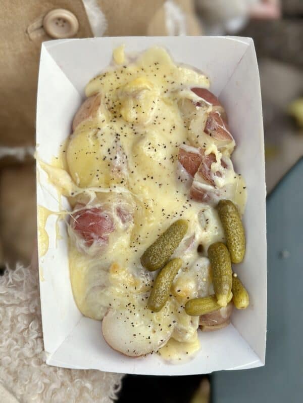 raclette on potatoes with cornichones and onions