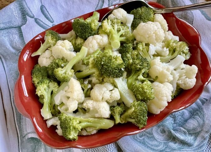 broccoli and cauliflower salad in a red dish