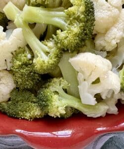 broccoli and cauliflower salad in a red dish