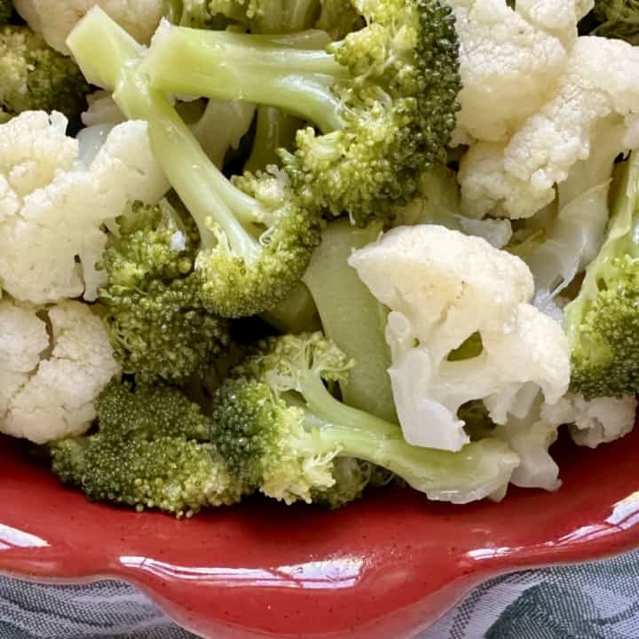 broccoli and cauliflower salad in a red dish