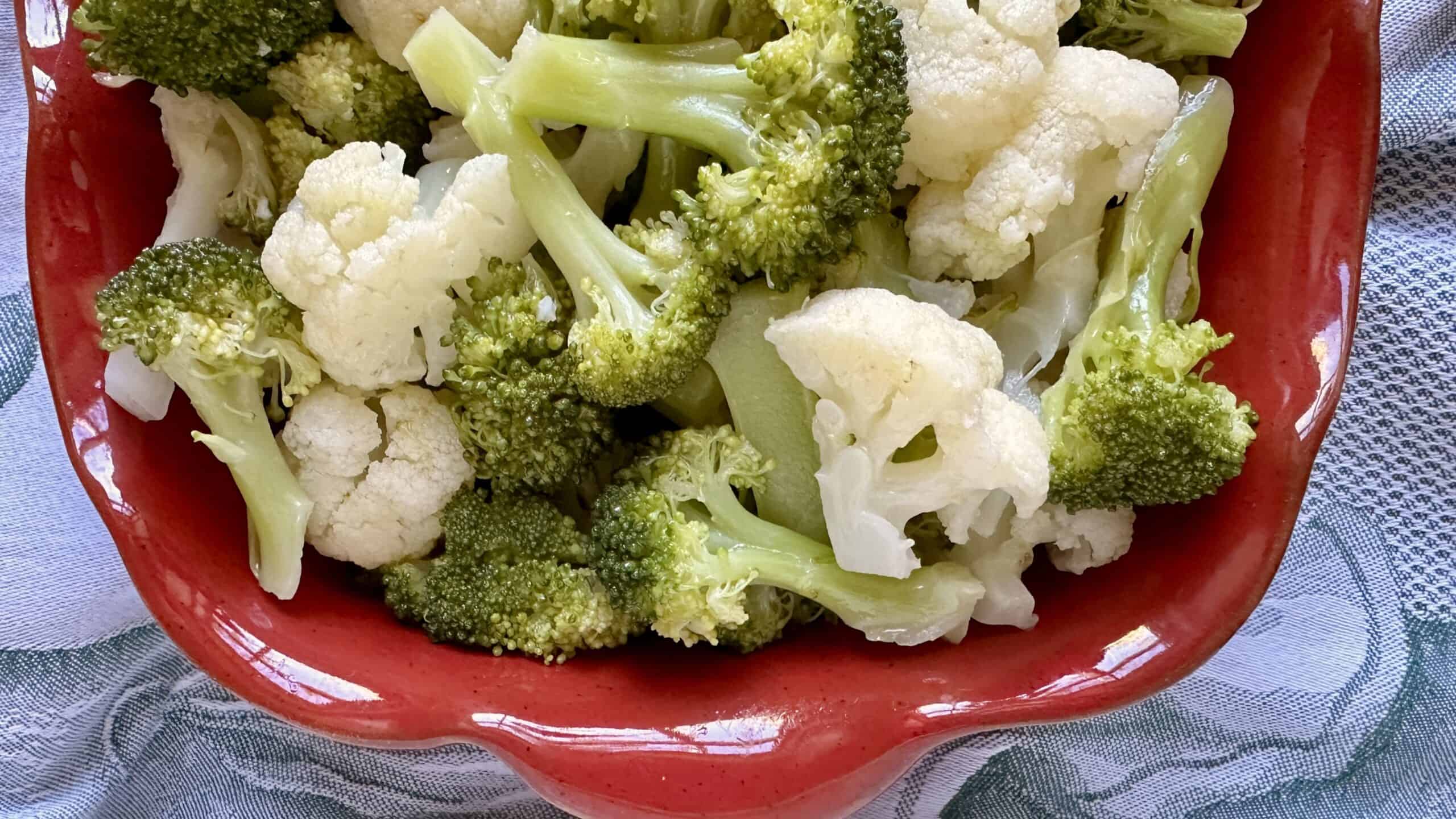 broccoli and cauliflower salad in a red dish
