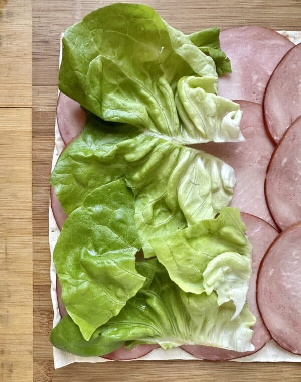 adding lettuce leaves to ham