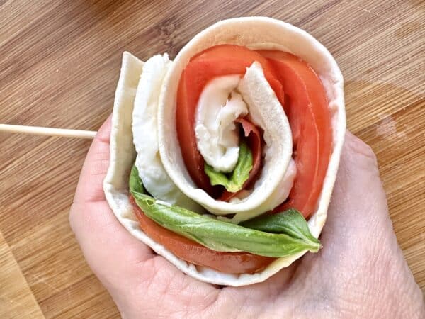 holding a Caprese pinwheel sandwich