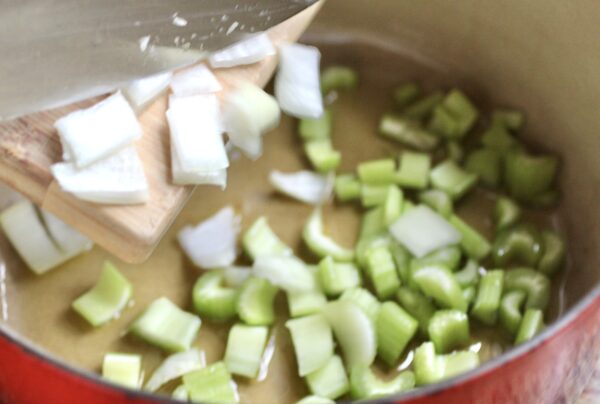 adding onion to celery in pot