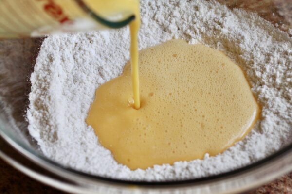 pouring eggs into flour