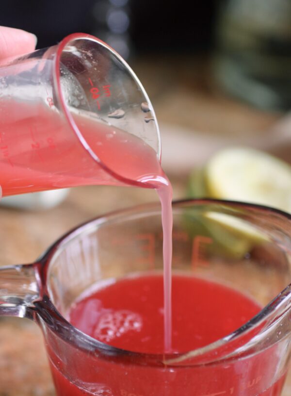 pouring blood orange juice into measuring cup