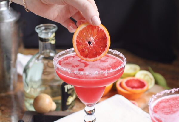 putting blood orange slice in margarita