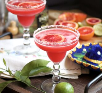 blood orange margarita on tray with lime for cinco de mayo