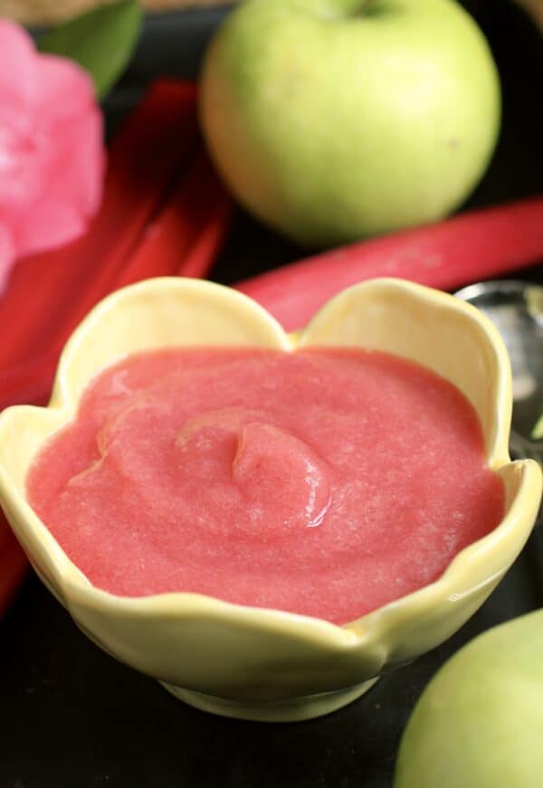 rhubarb applesauce in a yellow floral bowl with apples