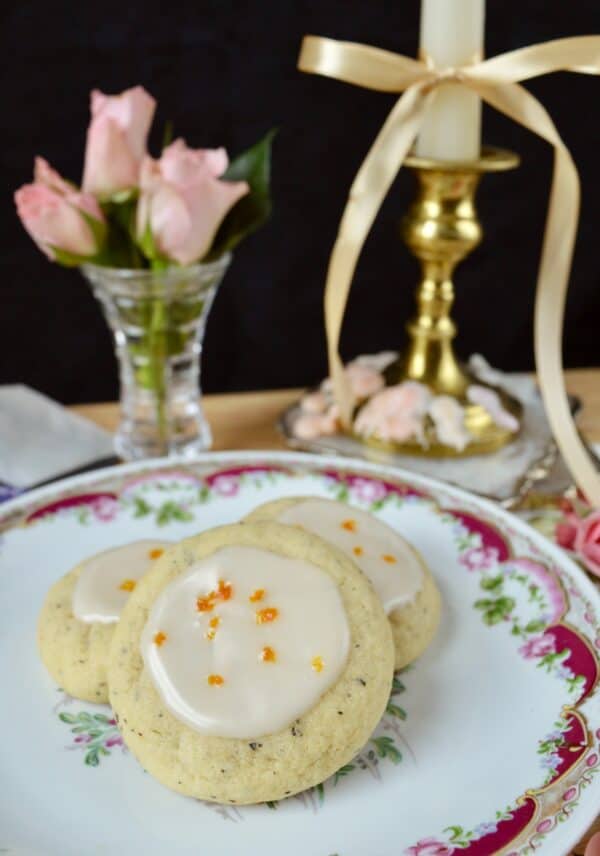 earl grey cookies with orange zest on plate with roses behind