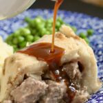pouring gravy onto steak pudding