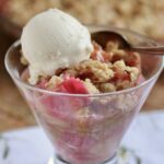 Rhubarb crisp in glass with scoop of vanilla ice cream