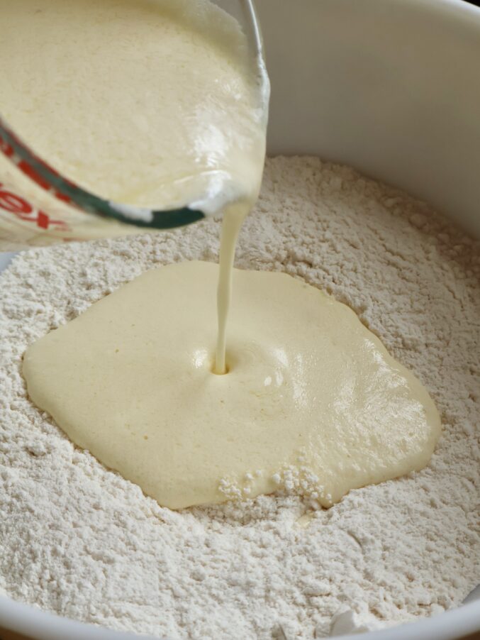 pouring yogurt mixture into flour
