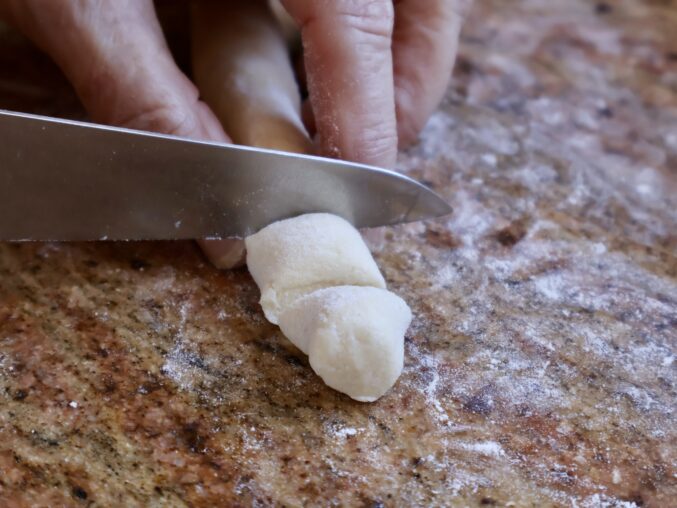 cutting the long rope of dough
