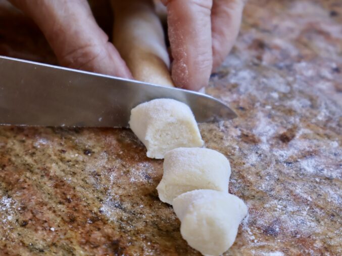 cutting the long rope of dough