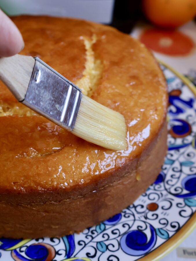 brushing glaze on cake