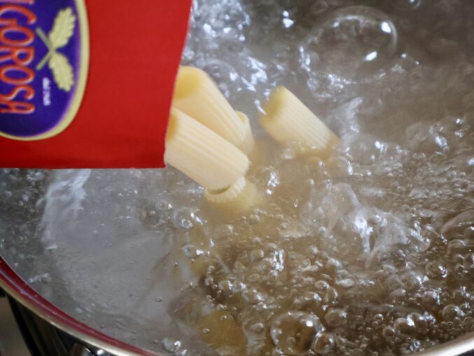 adding rigatoni to boiling water
