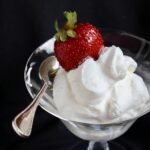 close up of glass of mascarpone cream with a strawberry