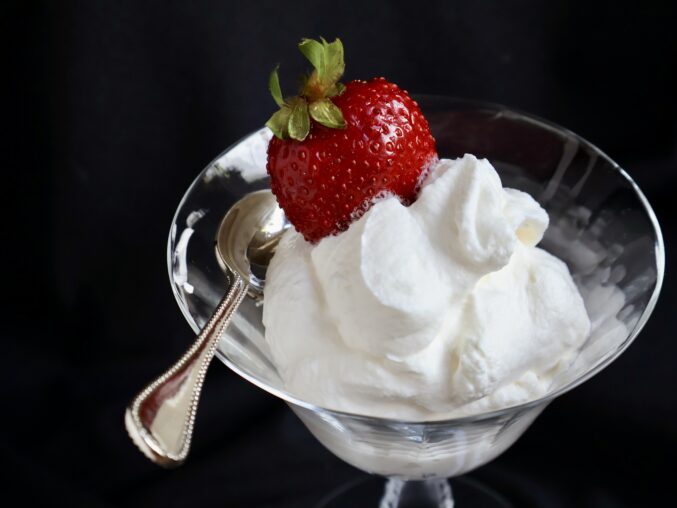 close up of glass of mascarpone cream with a strawberry
