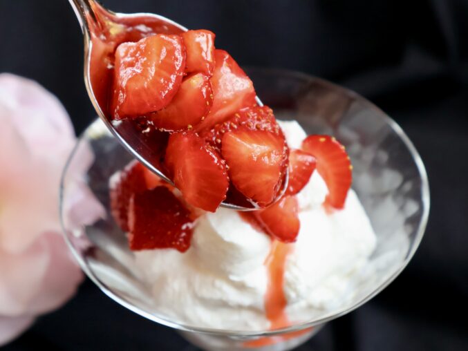 spooning strawberries over mascarpone cream