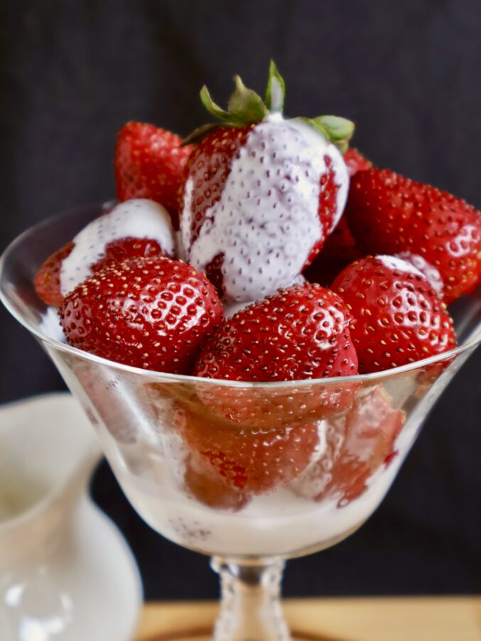 strawberries with poured cream in a coupe