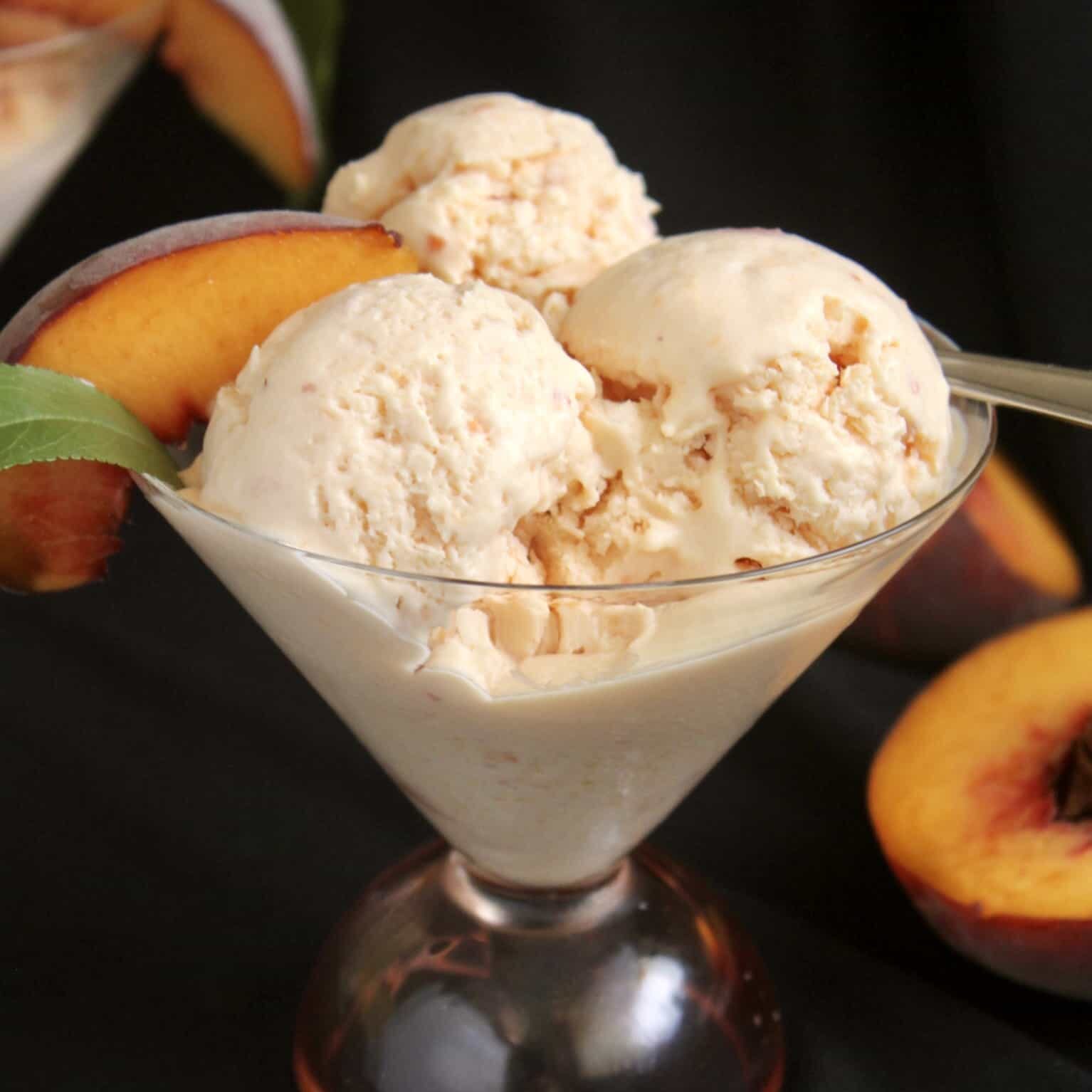 three scoops of peach ice cream in a glass