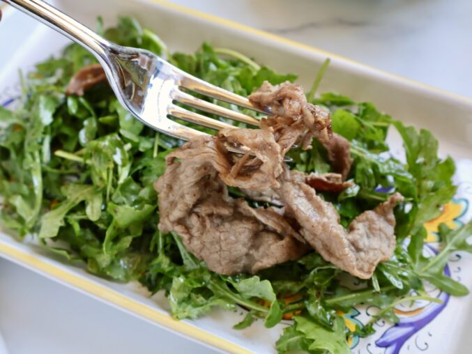 adding the straccetti to the salad