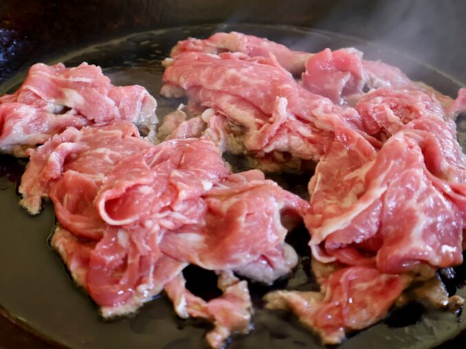 adding shaved beef to pan