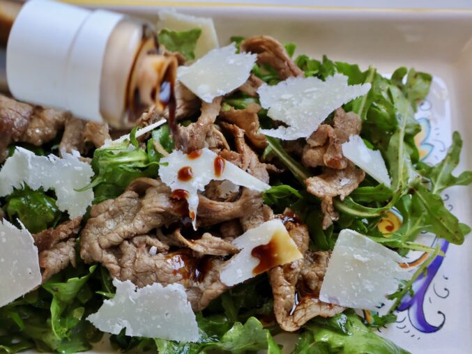 drizzling balsamic on the salad