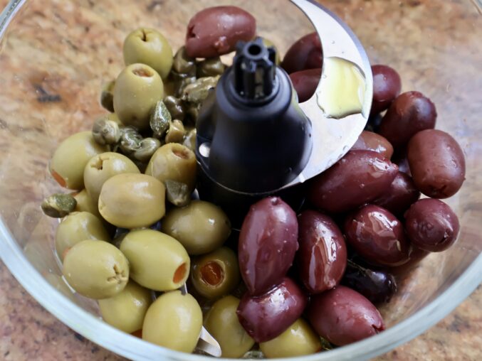 Adding all ingredients for olive tapenade recipe
