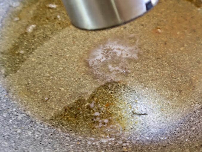 adding black pepper to the pan